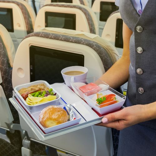 A flight attendant serving passengers on a plane