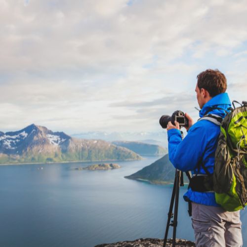 A freelance travel writer and photographer taking pictures of a lake