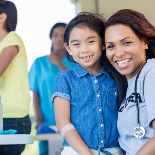 An image of a healthcare professional with a child, representing the opportunity for a job that travel in the healthcare industry.