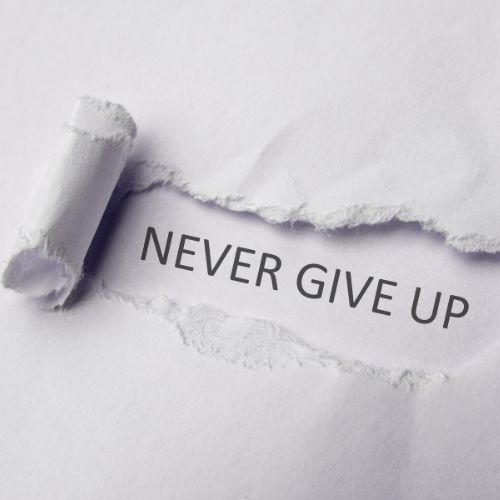 An image showing a piece of paper with the sentence never give up representing perseverance